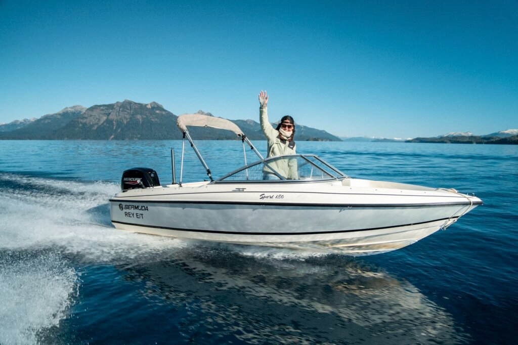 Lancha sport 180 bermuda vista lateral navegando, chica saluda